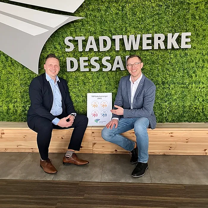 Mitarbeitende der Stadtwerke Dessau halten stolz die TOP-Lokalversorger-Urkunde in den Händen