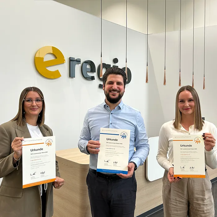 Mitarbeitende der E Regio halten stolz die TOP-Lokalversorger-Urkunde in den Händen